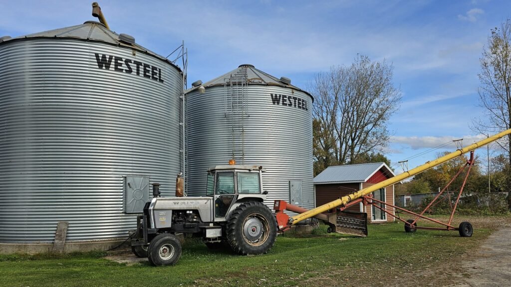 Silos à grain métalliques et tracteur sur une exploitation